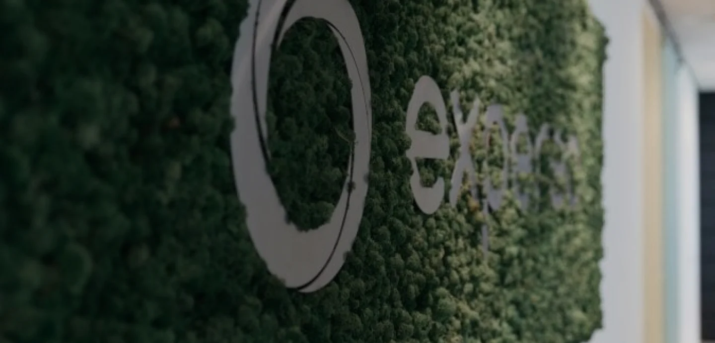 Blurred company logo displayed on a living moss wall in a modern office