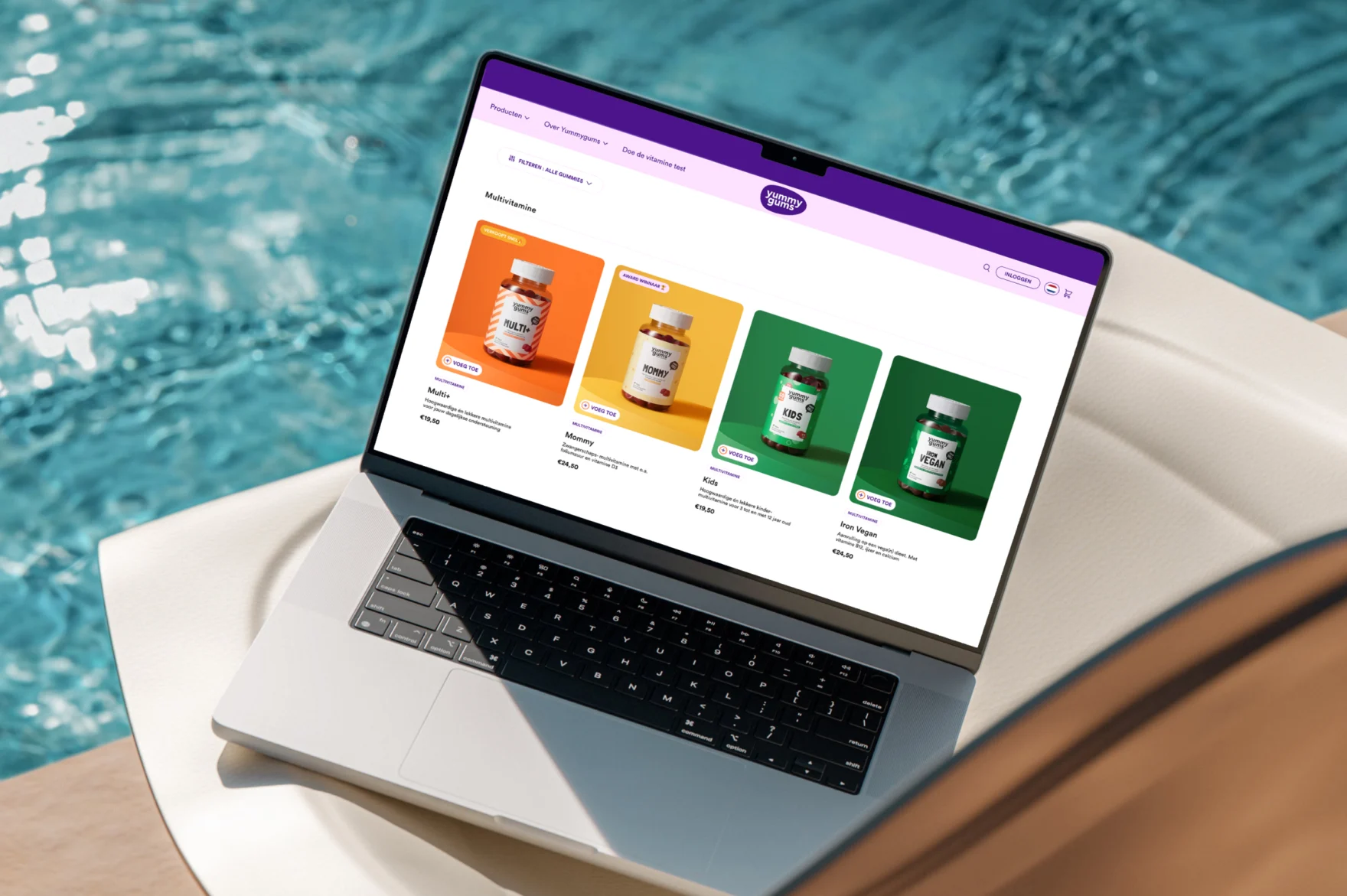 Productpagina van de Yummygums-webshop, weergegeven op een laptop aan het zwembad, met vitaminegummies