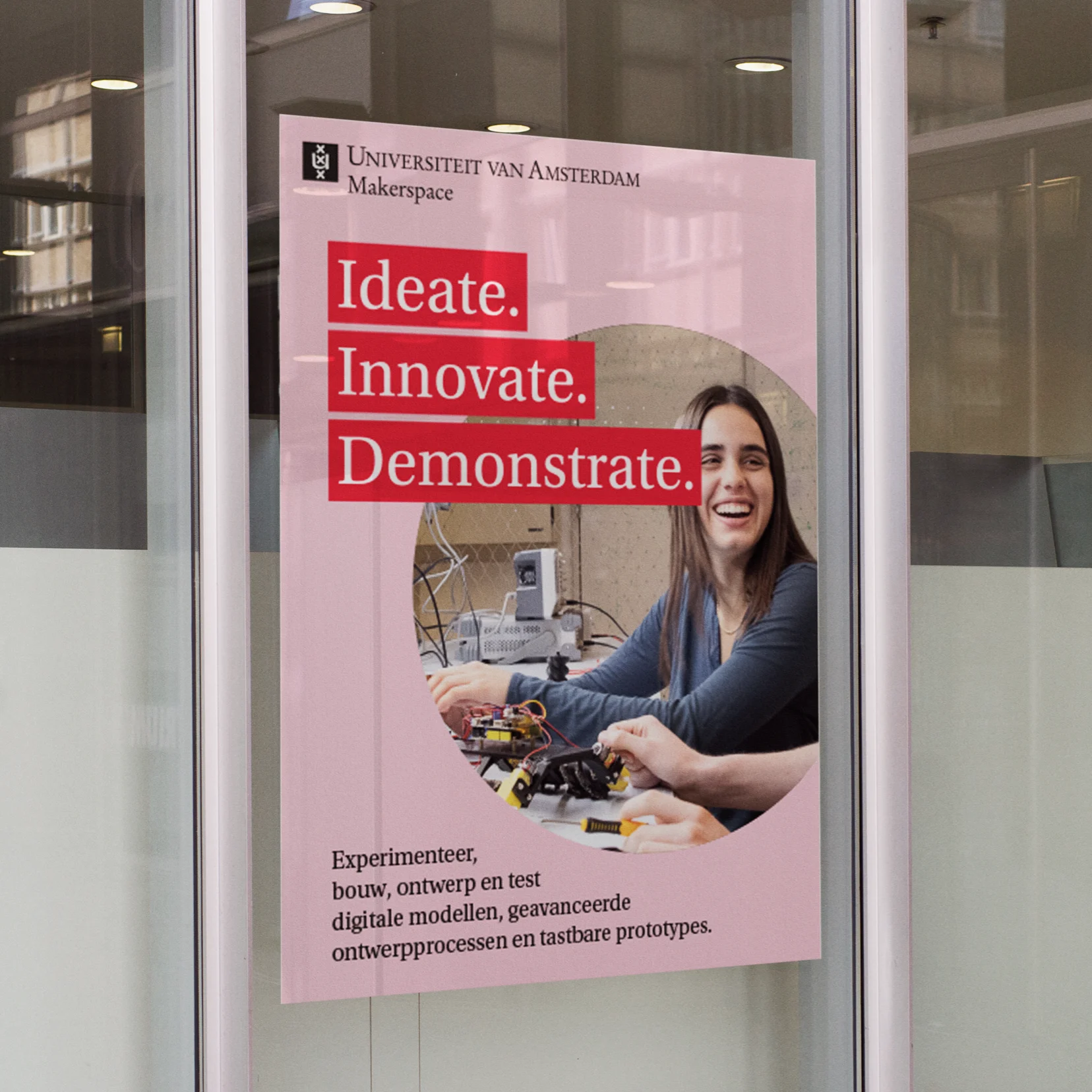 UvA Makerspace poster on a glass door featuring a student soldering electronics