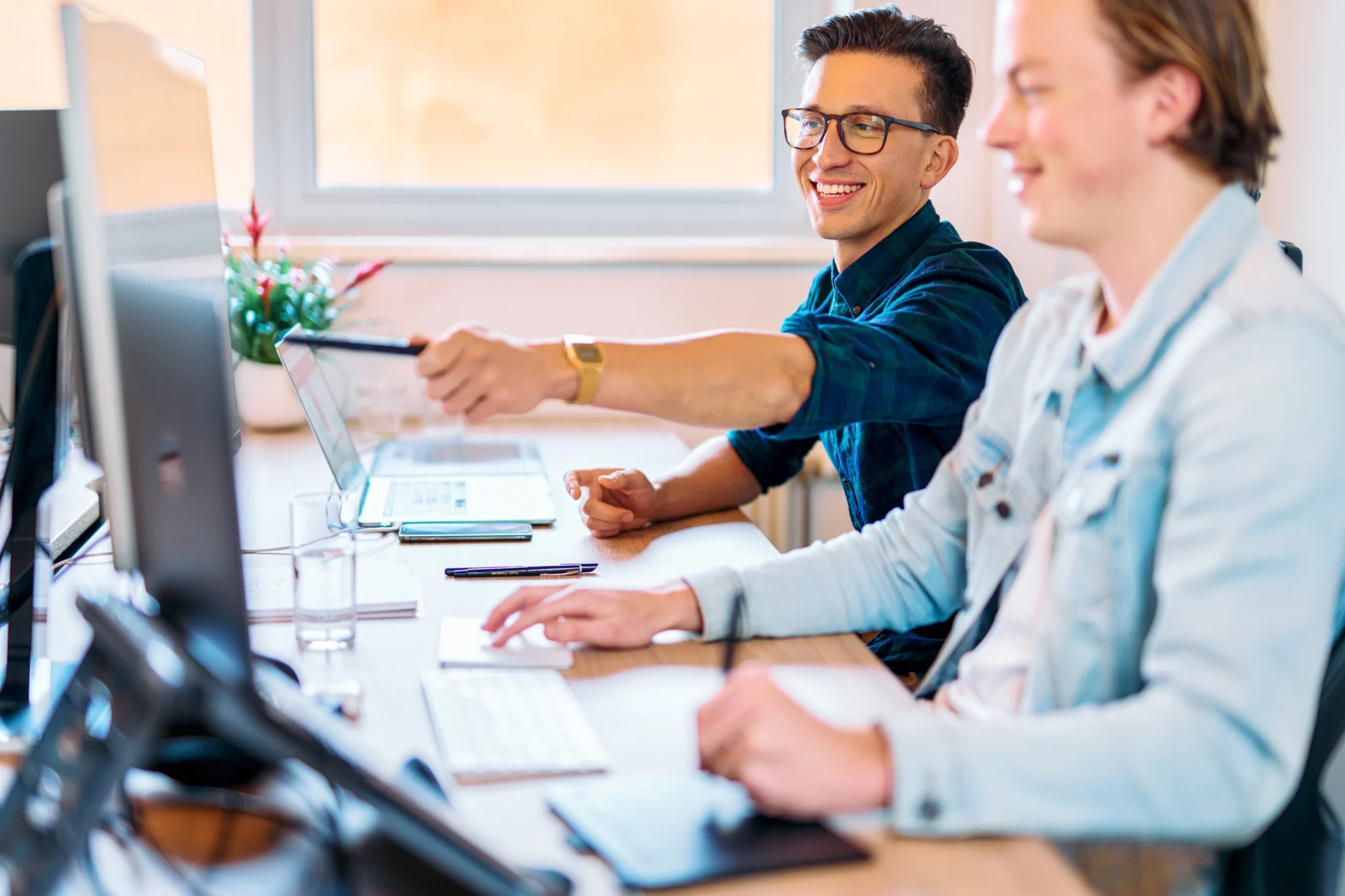 Mars colleagues smiling while discussing a website project at their office desks