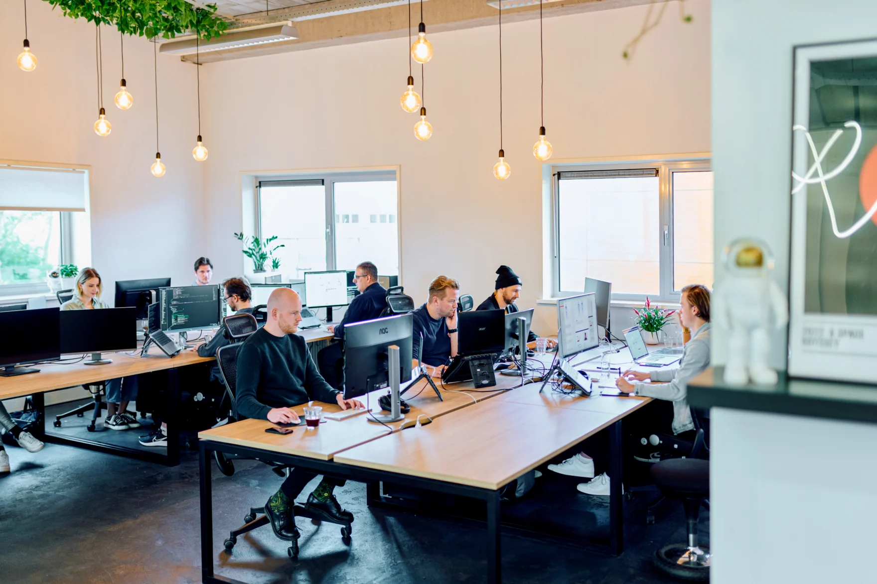 Mars office with team members working at desks under hanging pendant lights
