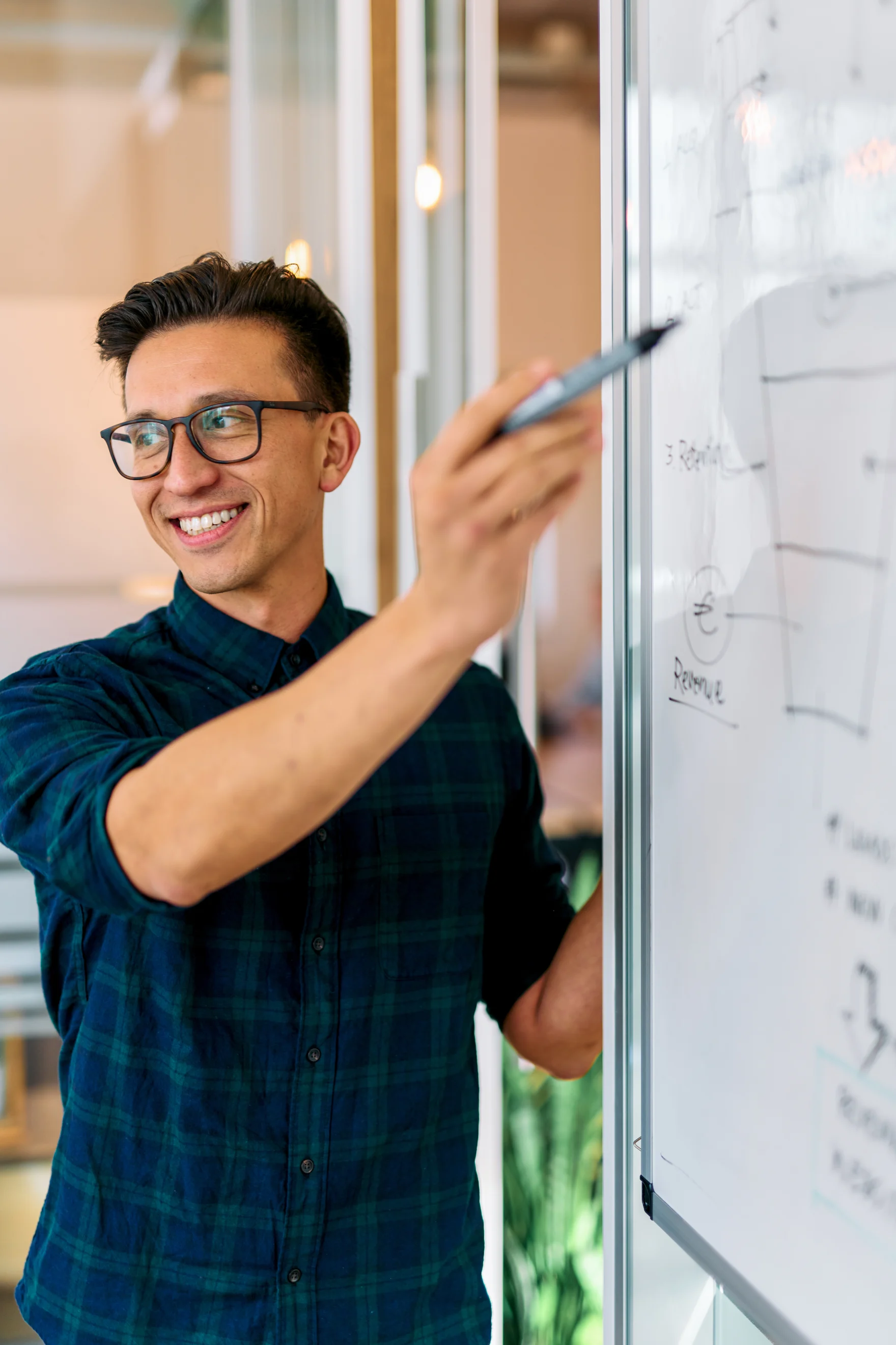 Mars employee smiling while pointing at a whiteboard growth strategy diagram