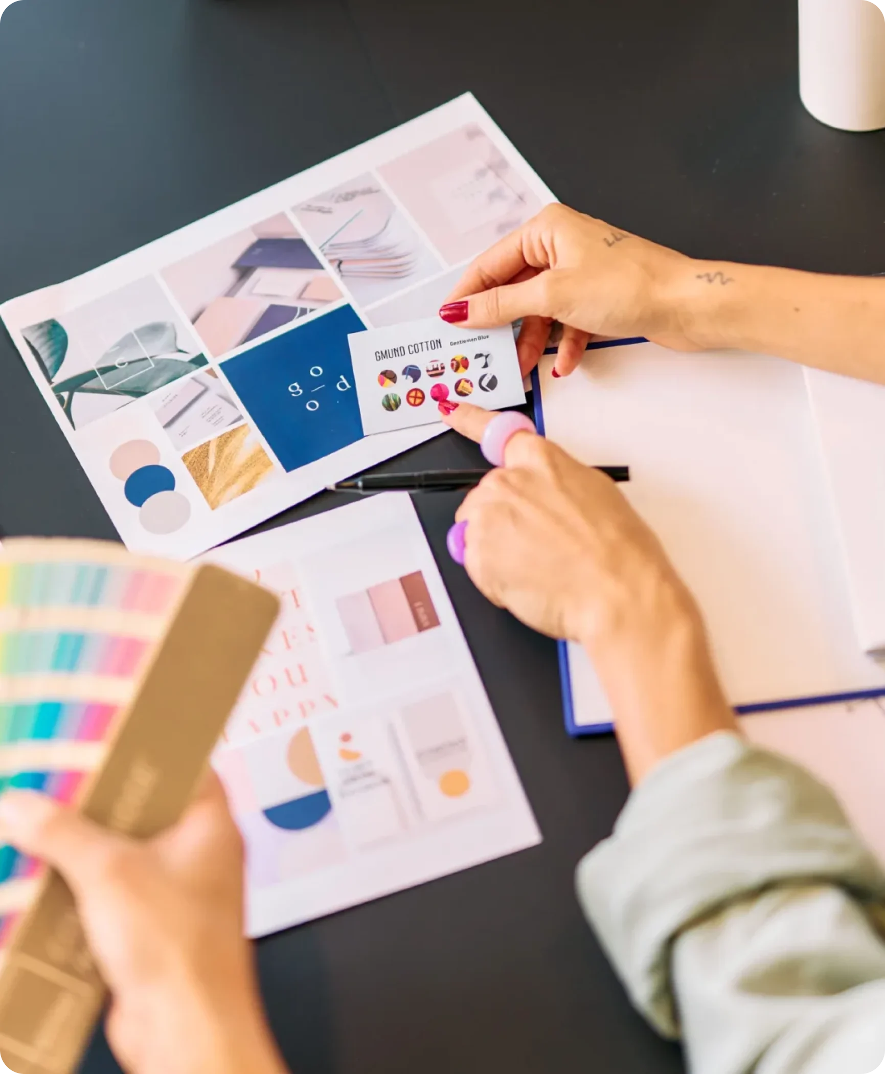 Designer arranging color swatches and business card samples on a brand moodboard