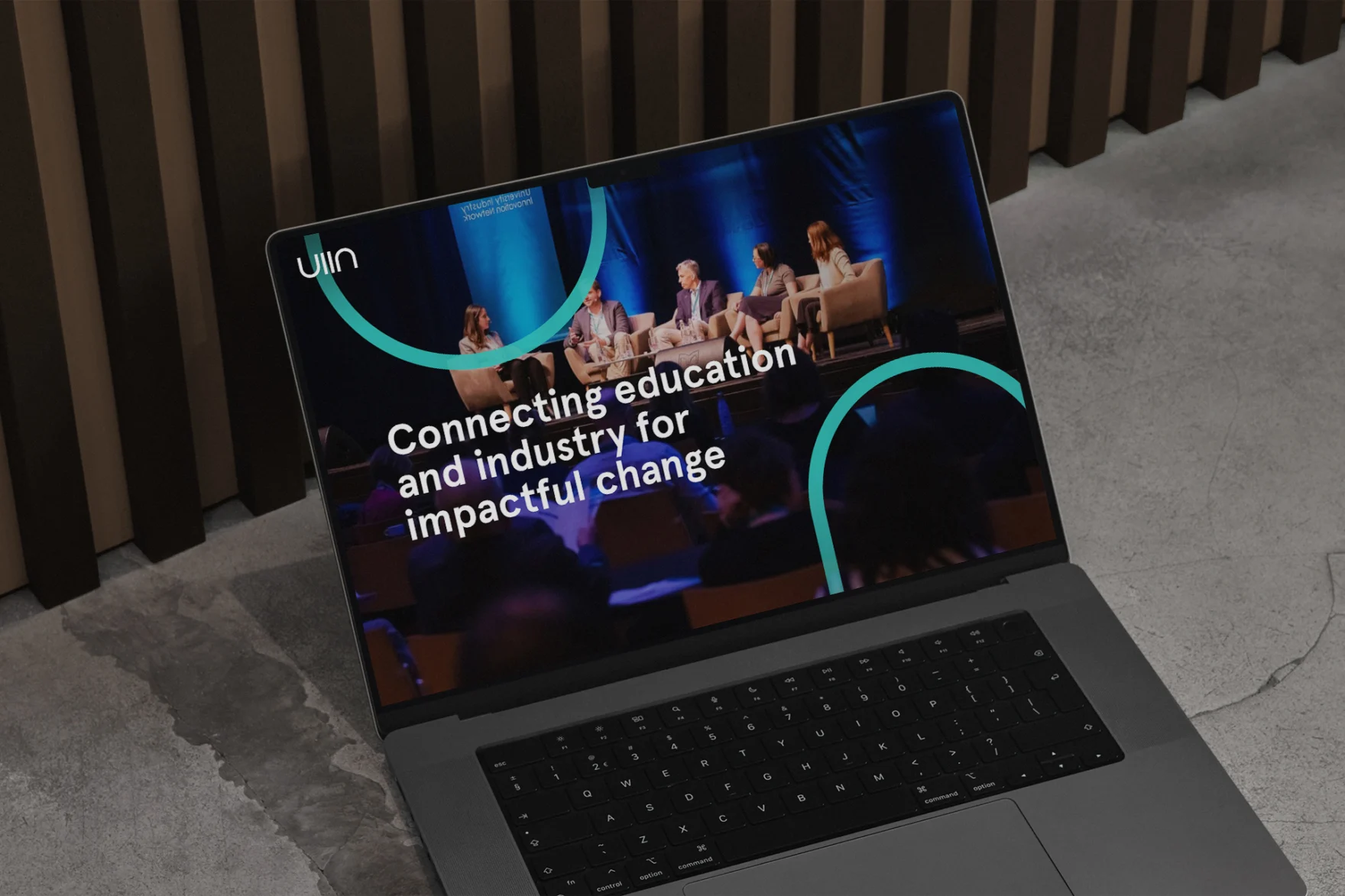 Laptop displaying the UIIN website homepage with a connecting education and industry headline