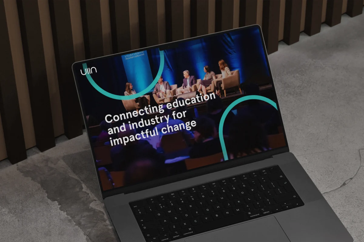 Laptop showing the UIIN website homepage with a conference photo