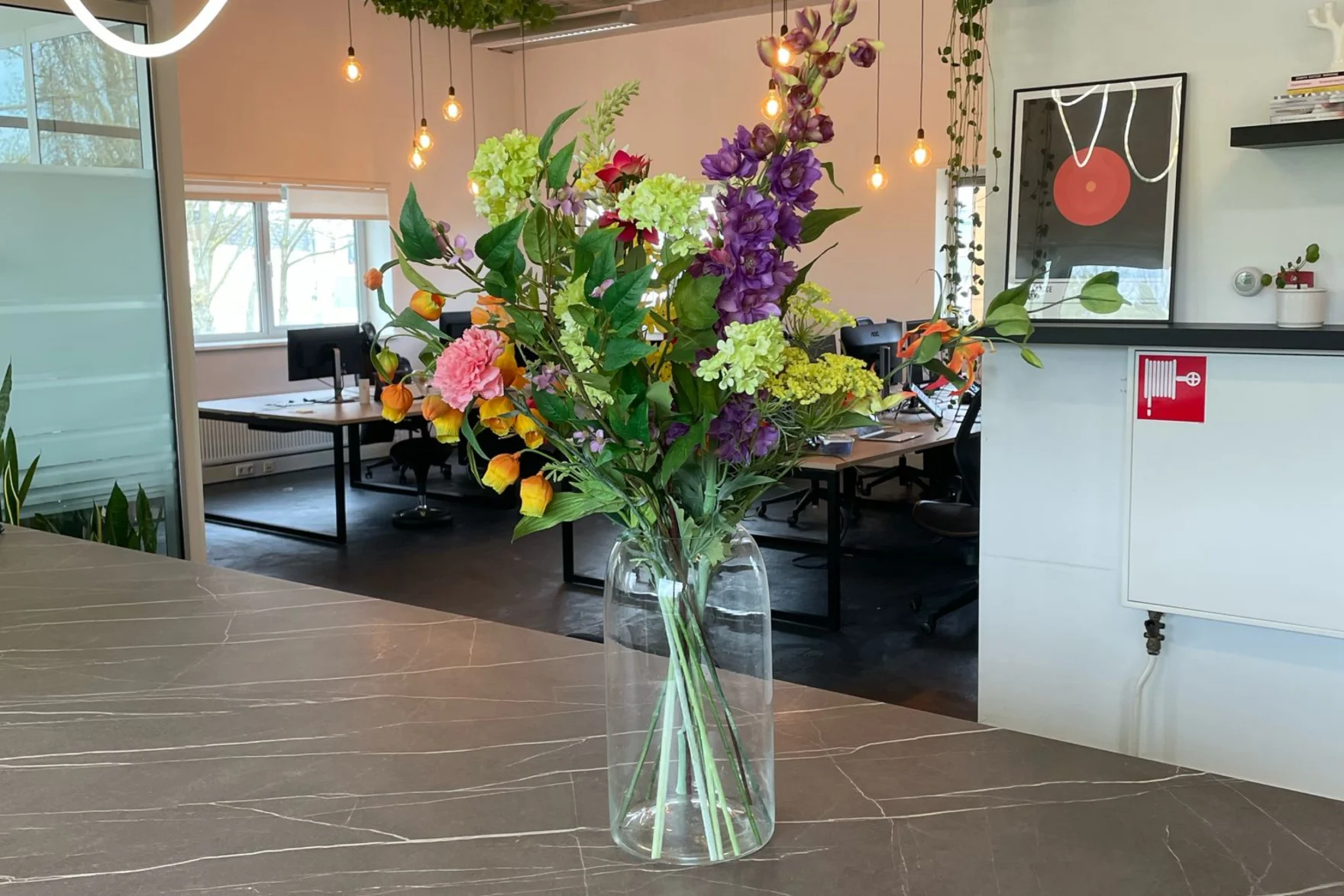 Colorful flower bouquet in a glass vase on the Mars office reception desk