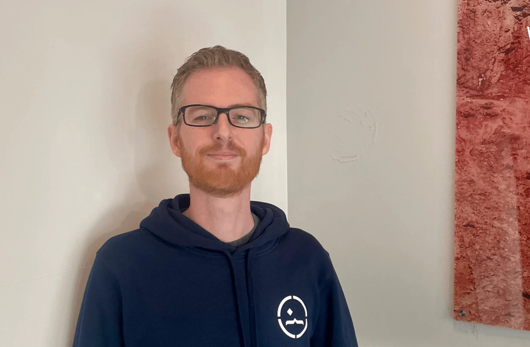 Rob, new developer at Mars, smiling in a navy Mars hoodie