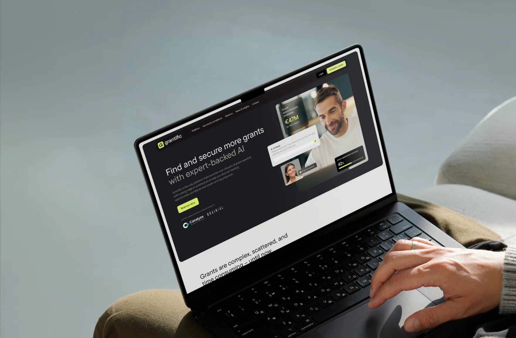 Close-up of the Grantific homepage on a laptop with a hand on the trackpad
